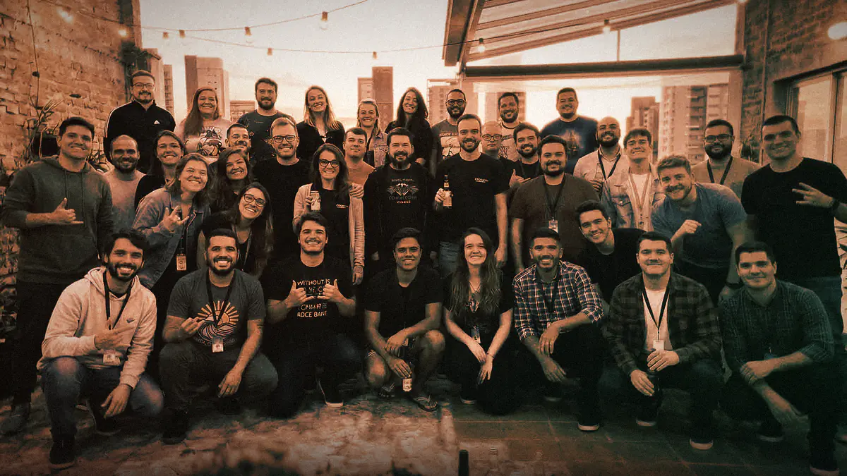 Foto do time do SeuSite24h reunido em um terraço ao fim da tarde, com a cidade ao fundo